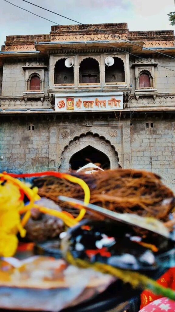काल भैरव मंदिर उज्जैन में भगवान भैरव की मूर्ति को मदिरा अर्पित करते हुए श्रद्धालु